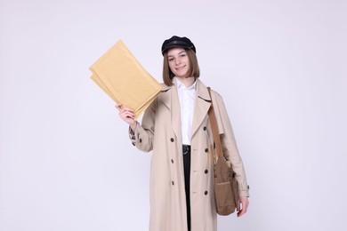 Photo of Happy postwoman with bag and envelopes on white background