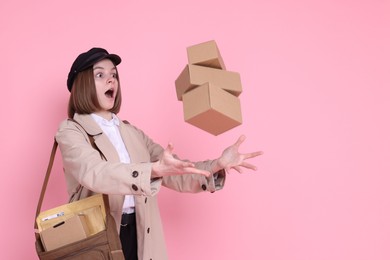 Photo of Funny postwoman with bag throwing parcels on pink background. Space for text