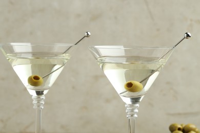 Photo of Martini cocktail with olives in glasses on light background, closeup