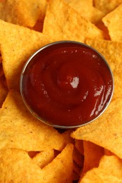 Photo of Tasty ketchup and nachos on plate, above view