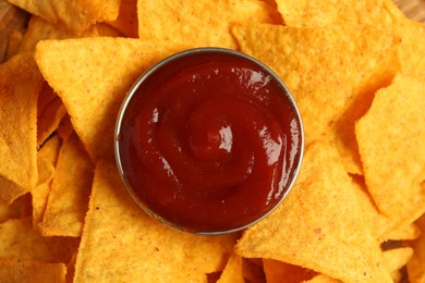 Photo of Tasty ketchup and nachos on plate, top view