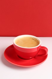 Photo of Red cup with coffee on white table