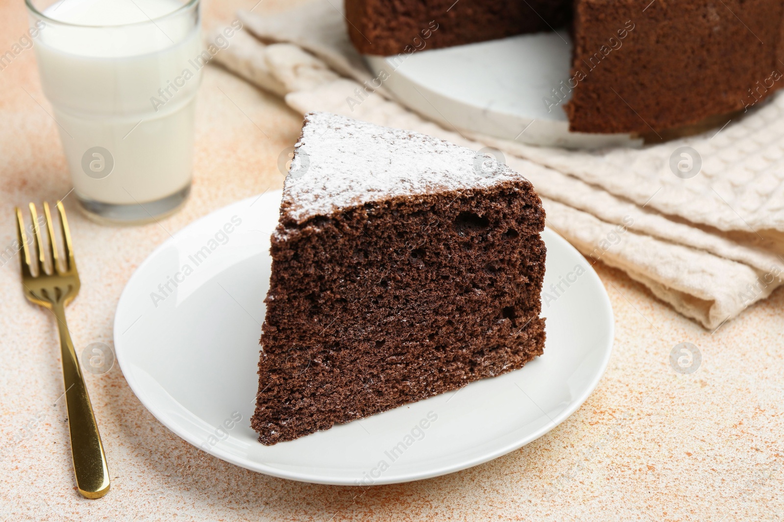 Photo of Piece of tasty chocolate sponge cake served on light table, closeup