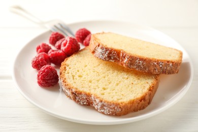 Photo of Freshly baked sponge cake and raspberries on white wooden table, closeup