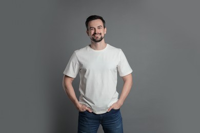 Photo of Man in blank white t-shirt on grey background. Mockup for design