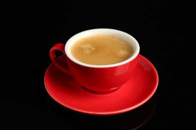 Photo of Red cup with coffee on black background, closeup