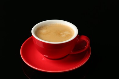 Photo of Red cup with coffee on black background, closeup