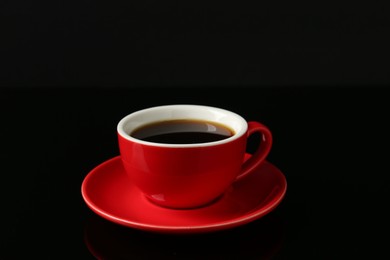 Photo of Red cup with coffee on black background