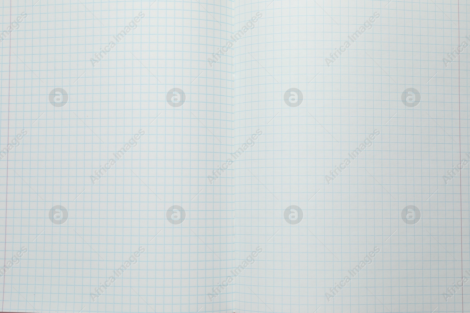 Photo of Open copybook with checkered sheets of paper as background, top view