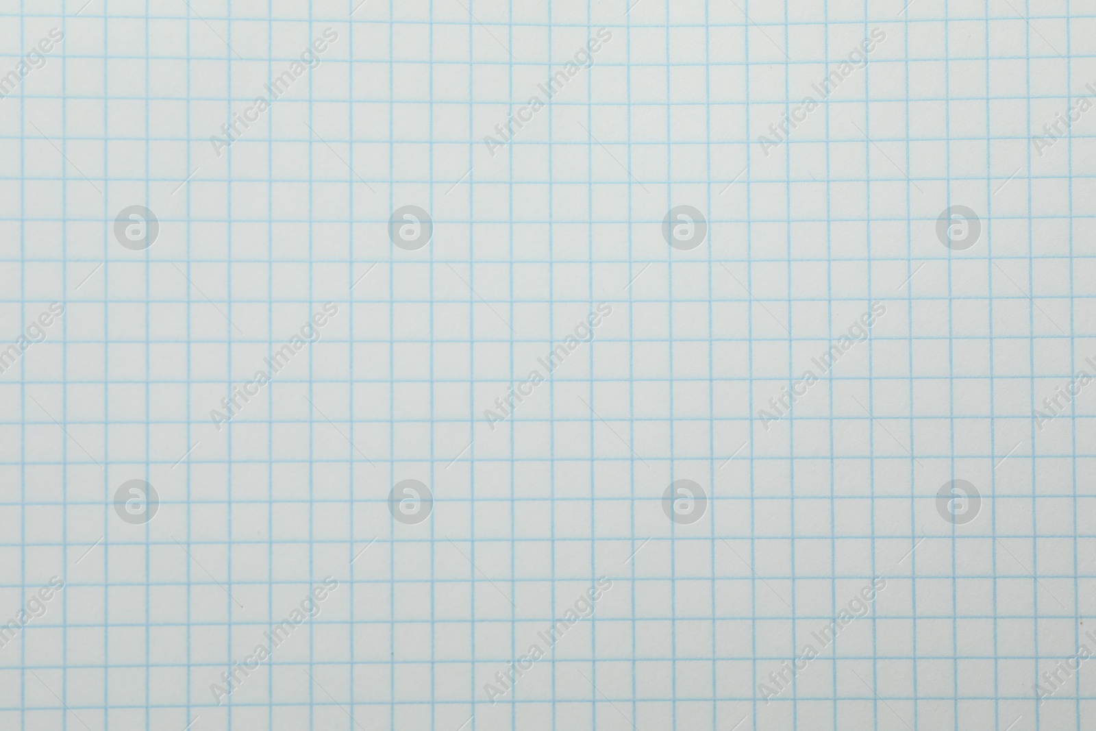 Photo of Checkered copybook sheet as background, top view. School stationery