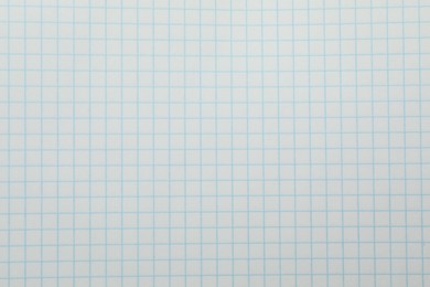 Photo of Checkered copybook sheet as background, top view. School stationery