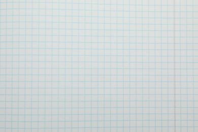 Photo of Checkered copybook sheet as background, top view. School stationery