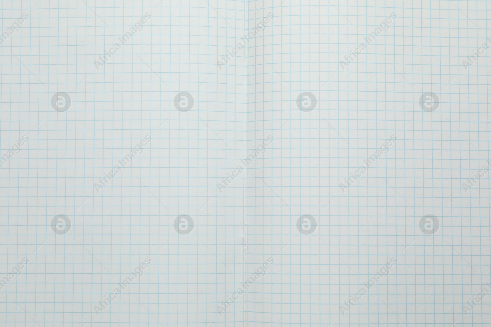 Photo of Open copybook with checkered sheets of paper as background, top view