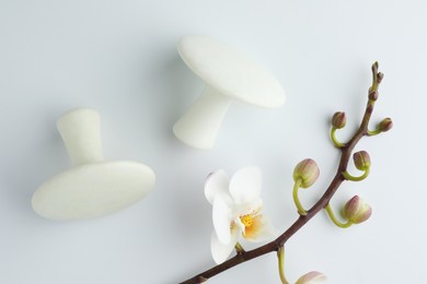 Photo of Spa stones and orchid branch on white background, flat lay