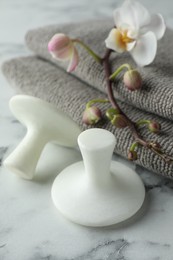 Spa stones, orchid branch and towels on white marble table, closeup