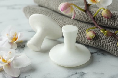 Photo of Spa stones, orchid flowers and towels on white marble table, closeup