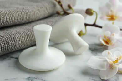 Photo of Spa stones, orchid flowers and towels on white marble table, closeup