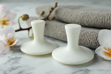 Spa stones, orchid flowers and towels on white marble table, closeup