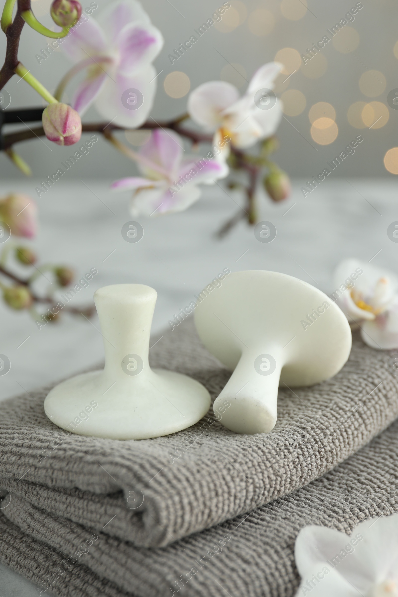 Photo of Spa stones, orchid flowers and towels on table, closeup