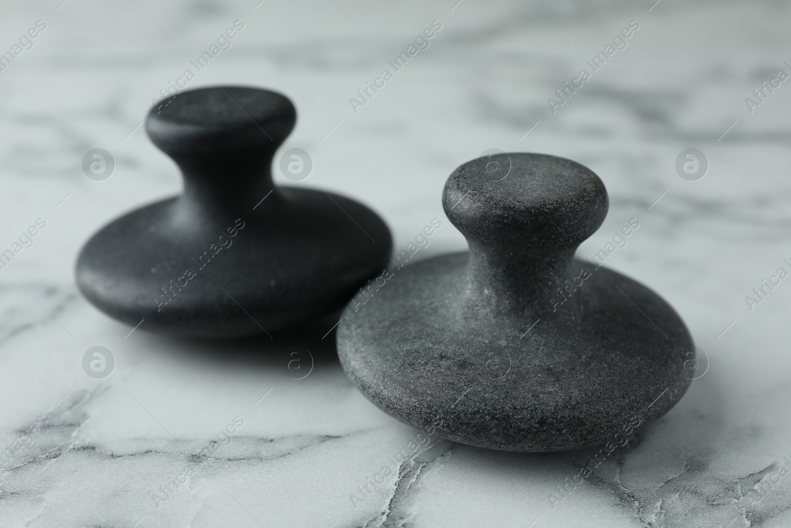 Photo of Spa stones on white marble table, closeup