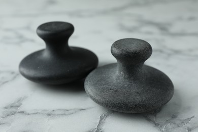 Spa stones on white marble table, closeup