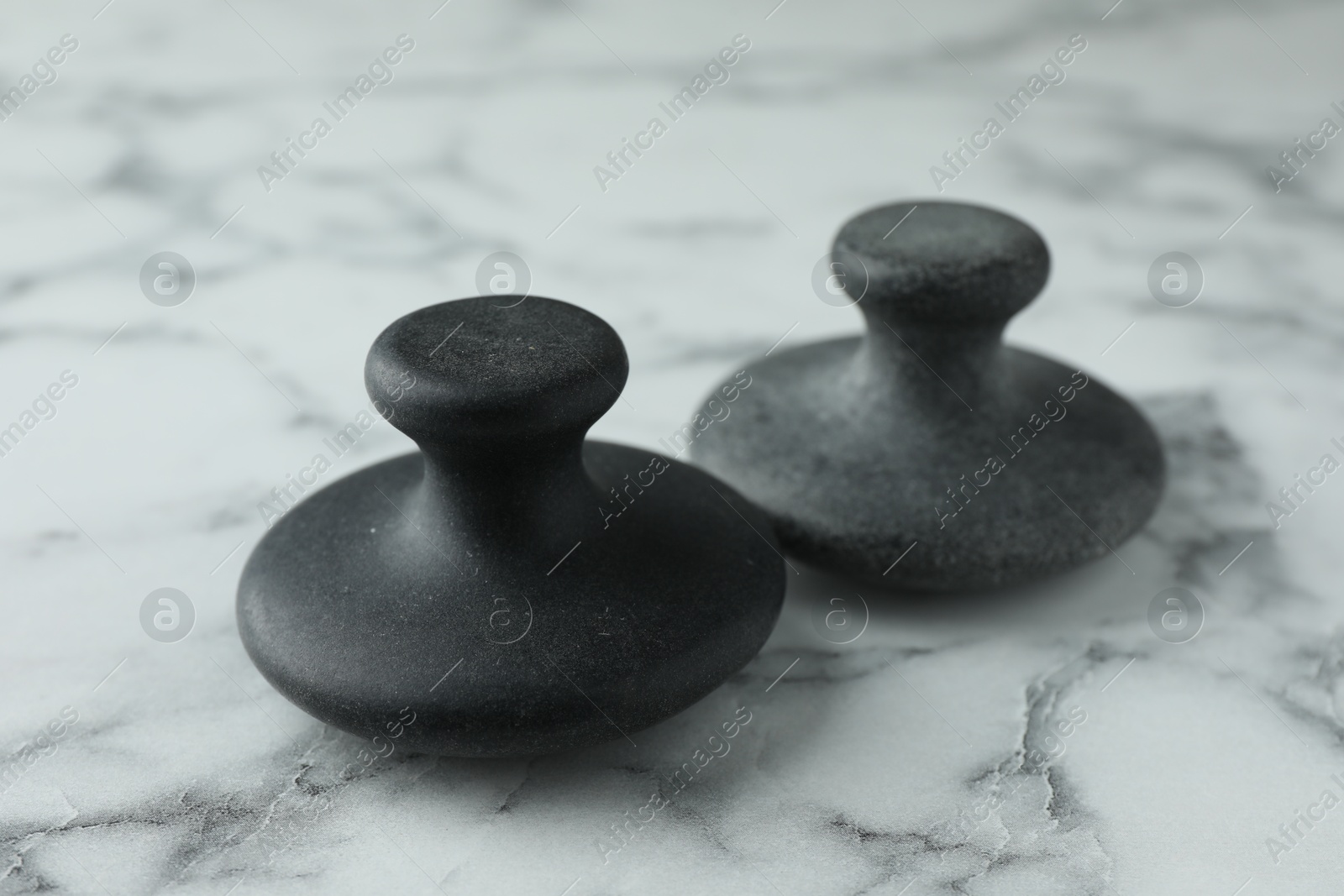 Photo of Spa stones on white marble table, closeup