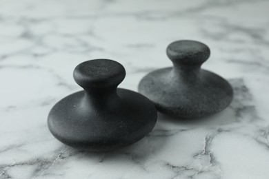 Photo of Spa stones on white marble table, closeup