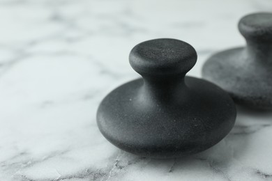 Photo of Spa stones on white marble table, closeup. Space for text