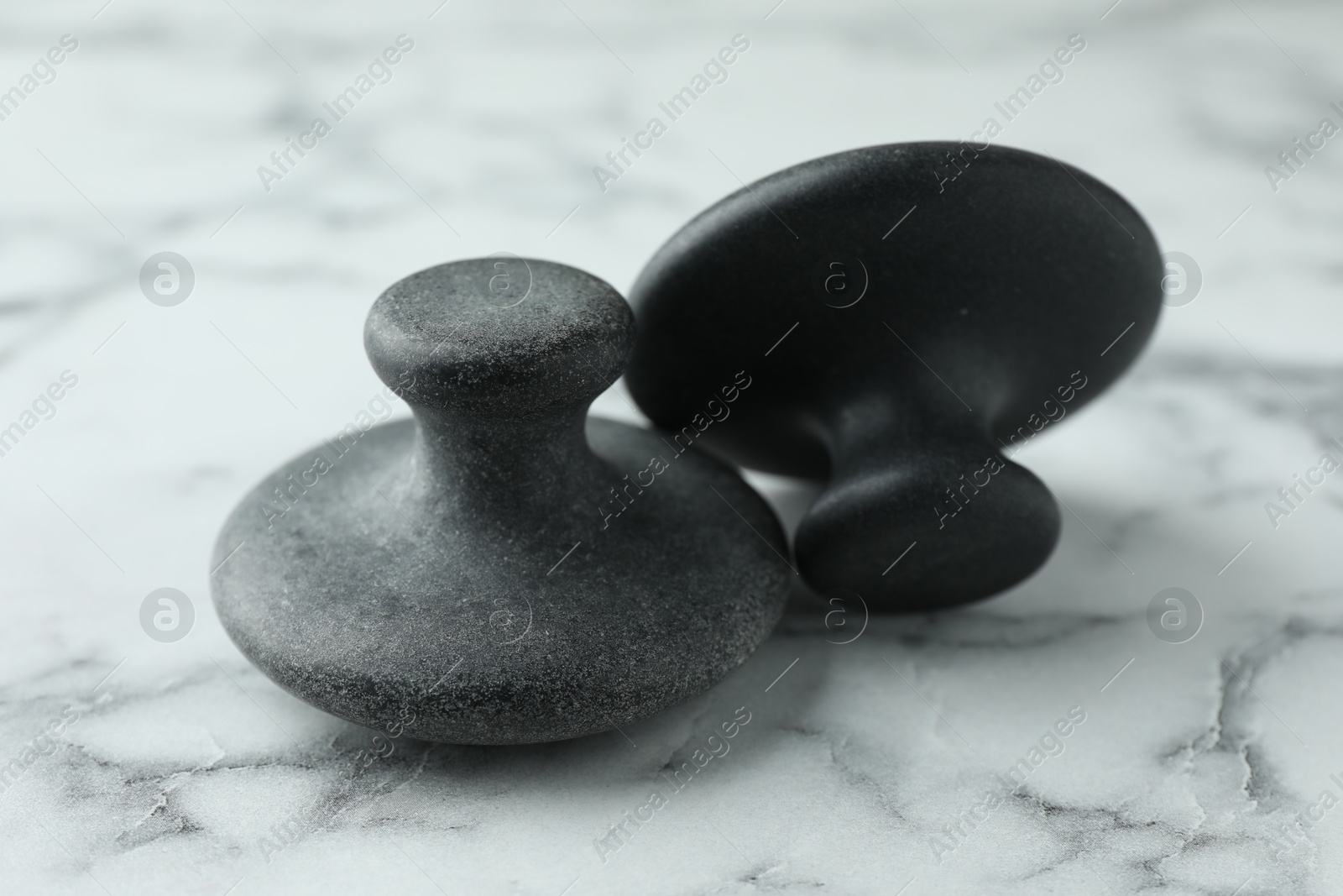 Photo of Spa stones on white marble table, closeup