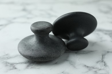 Photo of Spa stones on white marble table, closeup