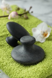 Spa stones, orchid flower and towel on table, closeup