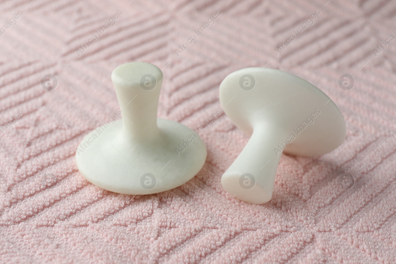 Photo of Two spa stones on pink towel, closeup