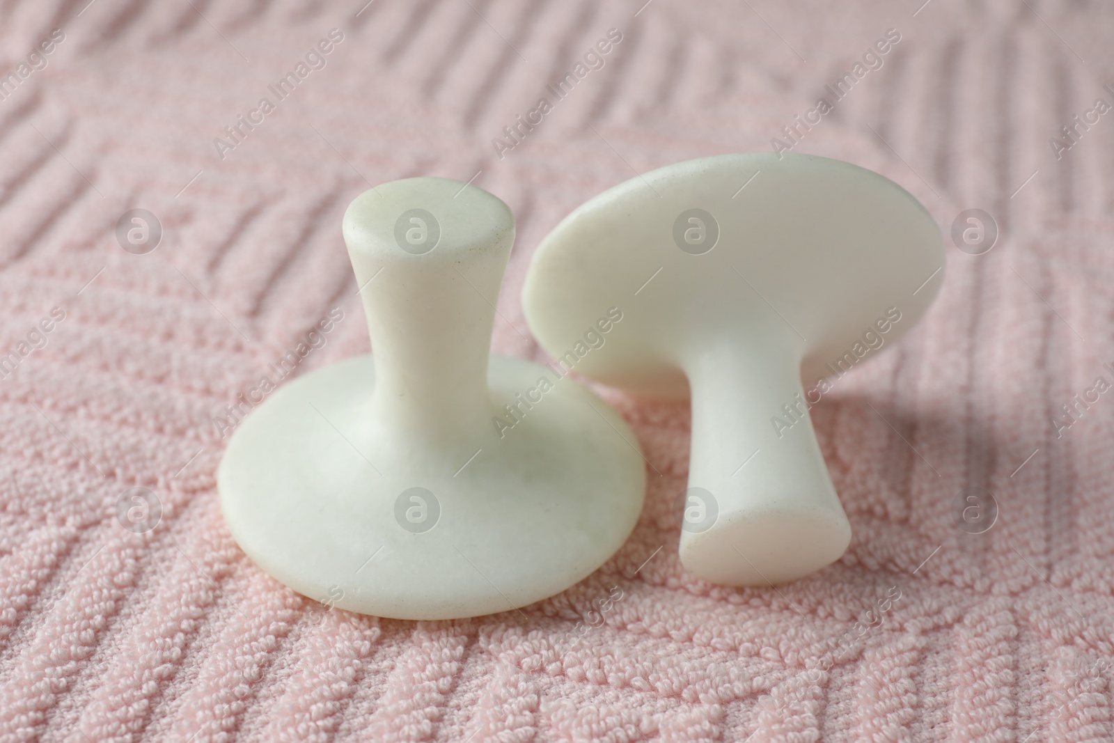 Photo of Two spa stones on pink towel, closeup