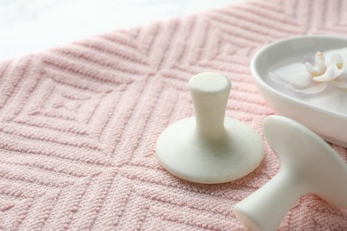 Photo of Spa stones, flower and pink towel on table, closeup. Space for text