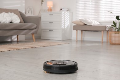 Photo of Robotic vacuum cleaner on wooden floor in living room