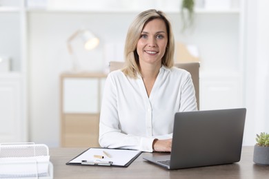 Photo of Portrait of businesswoman at table in office