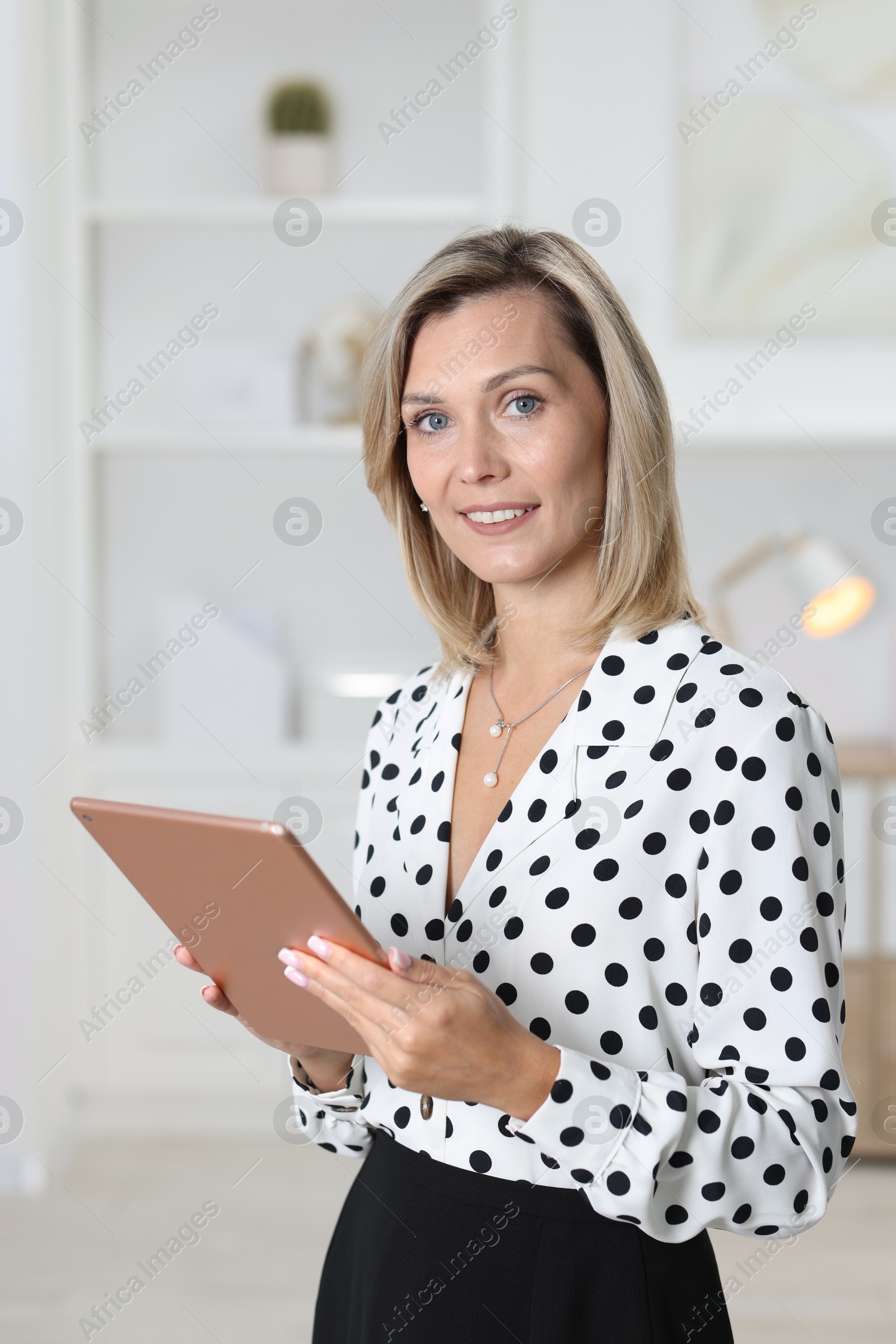 Photo of Portrait of happy businesswoman using tablet in office