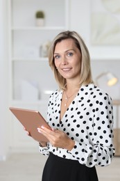 Photo of Portrait of happy businesswoman using tablet in office