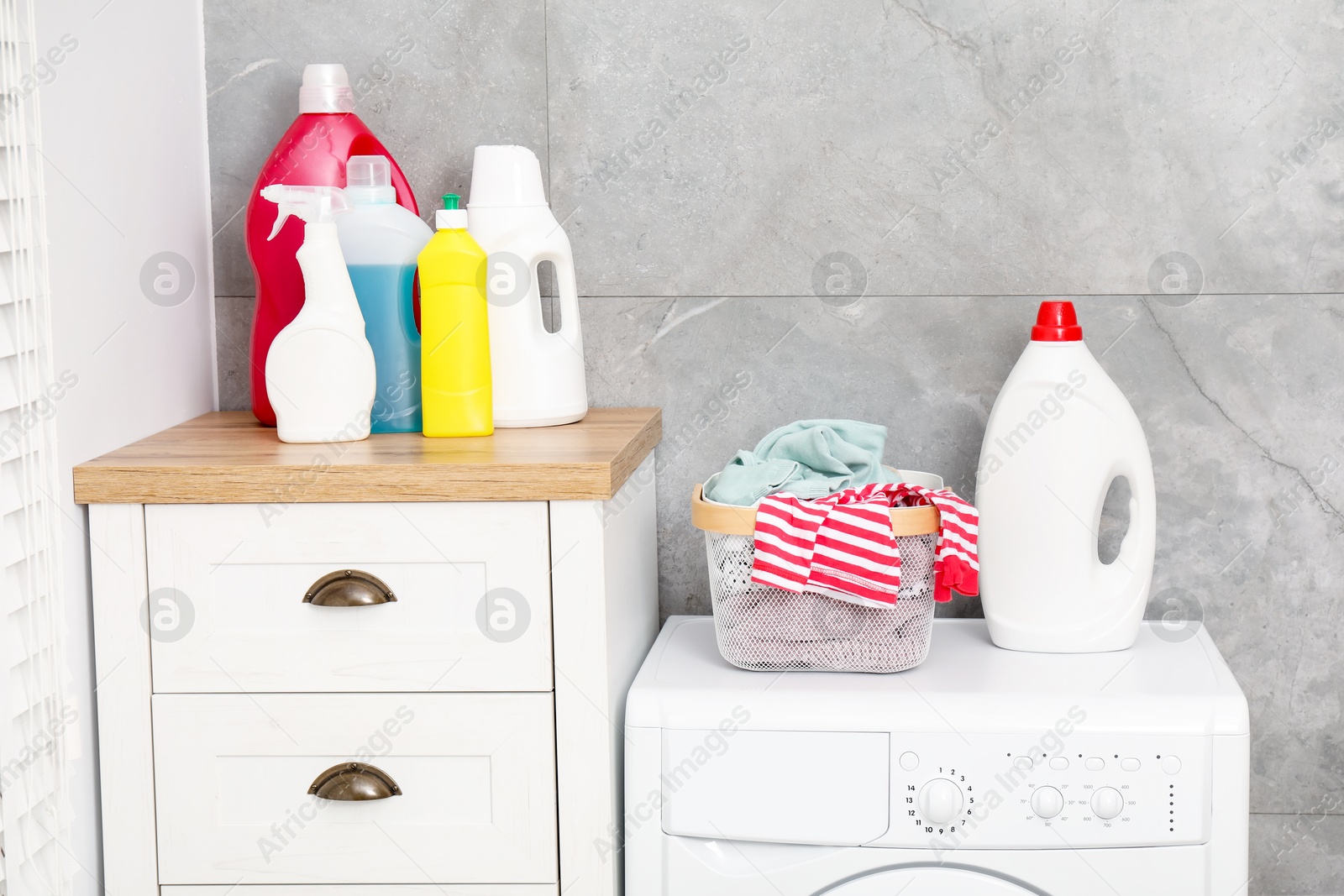 Photo of Detergents, basket with laundry and washing machine indoors