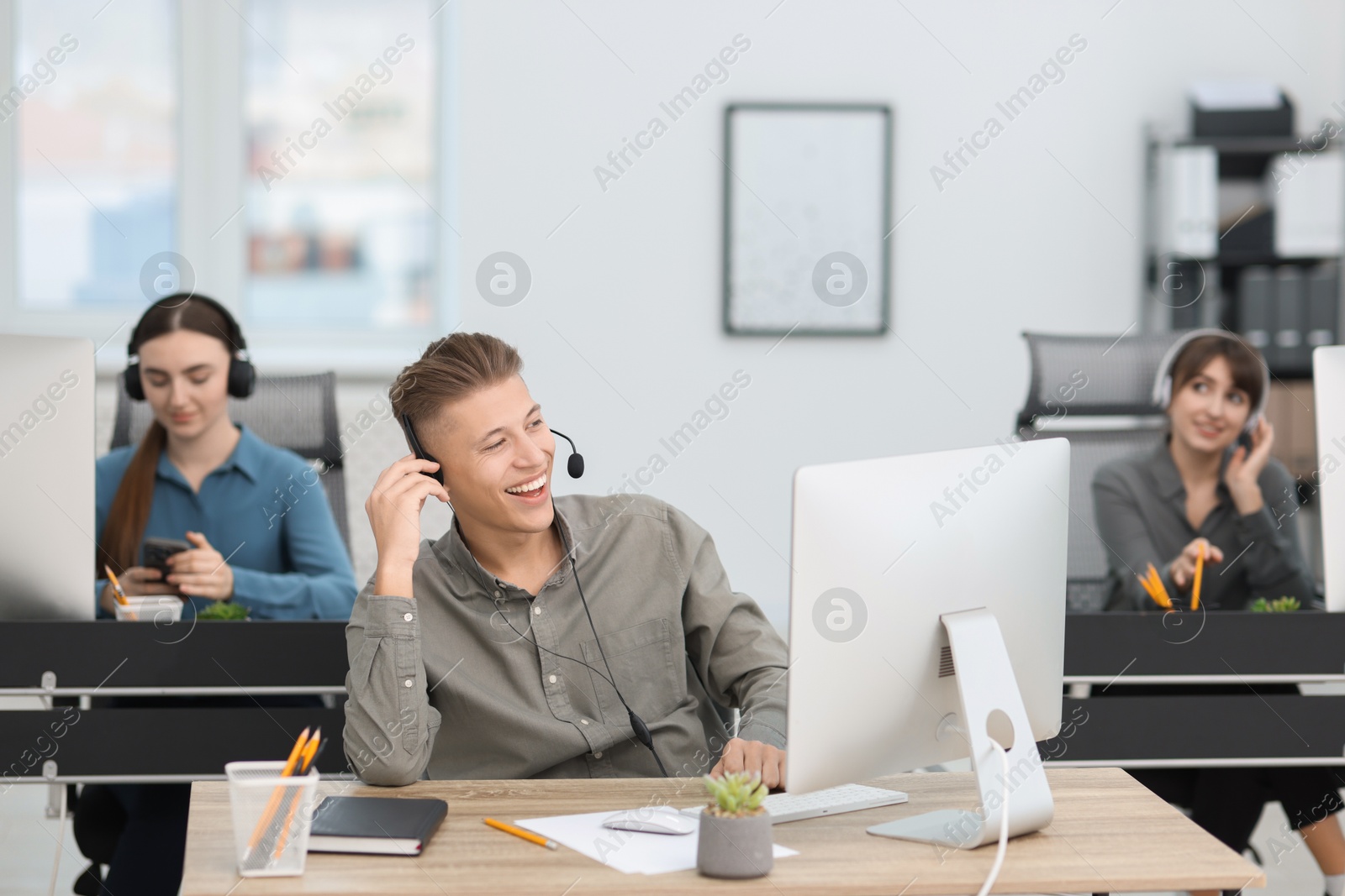 Photo of Sales department. People with headsets working in office, selective focus