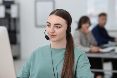 Photo of Saleswoman talking to client via headset in office