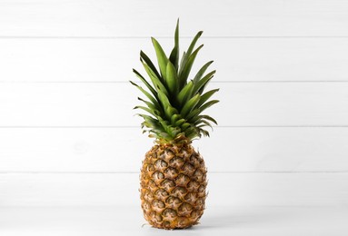 Photo of One fresh ripe pineapple on white table