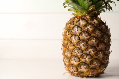 Photo of One fresh ripe pineapple on white table, space for text