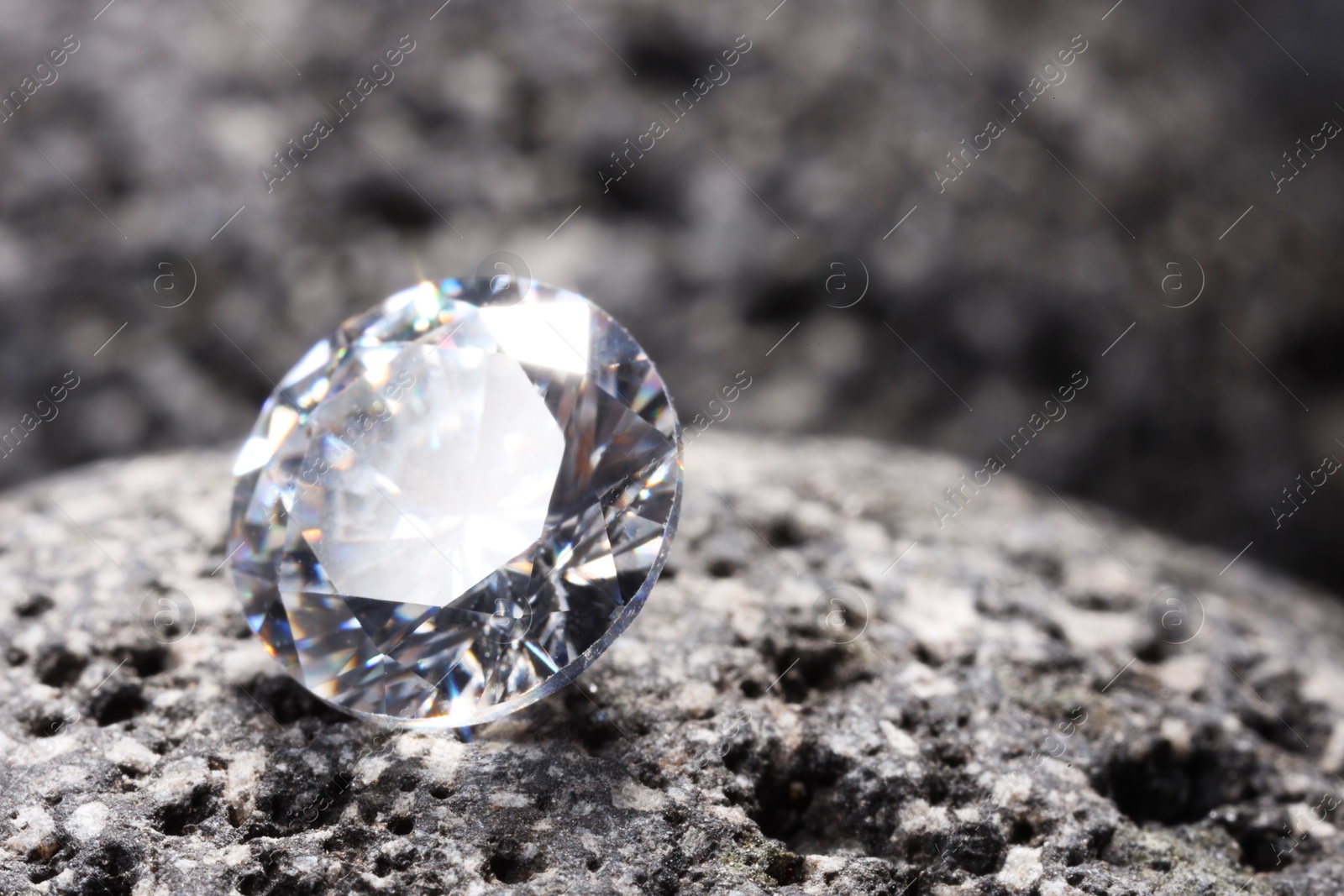 Photo of Beautiful shiny gemstone on stone, closeup. Space for text