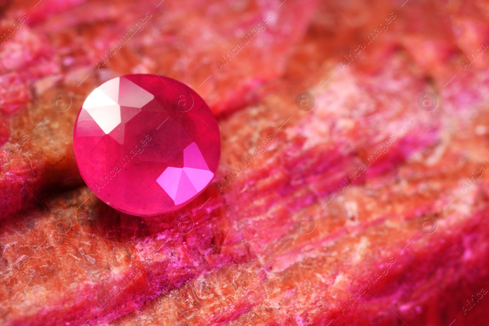 Photo of Beautiful shiny pink gemstone on natural mineral, closeup