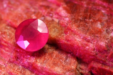 Beautiful shiny pink gemstone on natural mineral, closeup