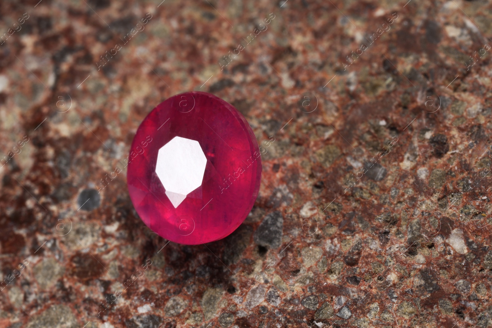 Photo of Beautiful shiny pink gemstone on rock, closeup