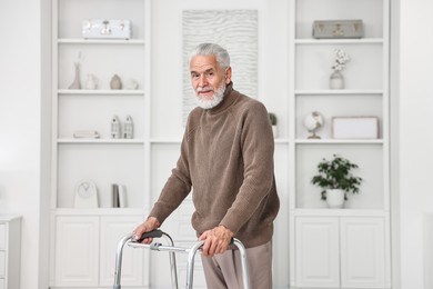 Photo of Senior man using walking frame at home