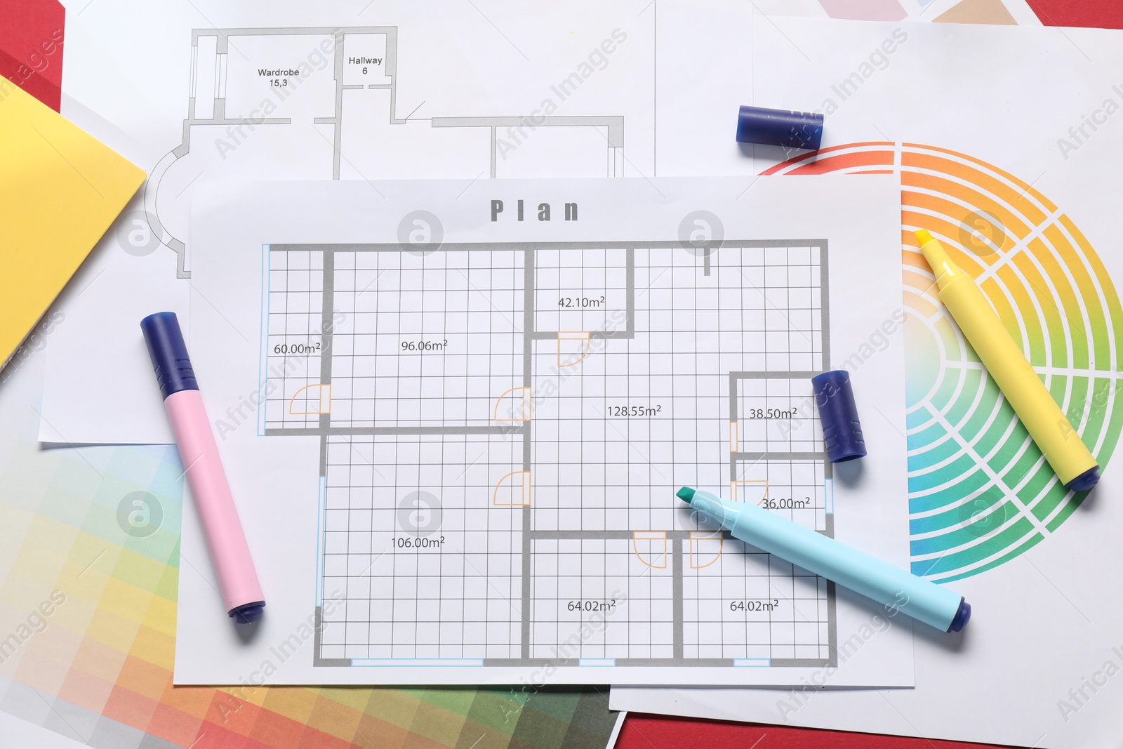 Photo of Designer's workplace with house plans, color palettes and felt pens on red table, flat lay