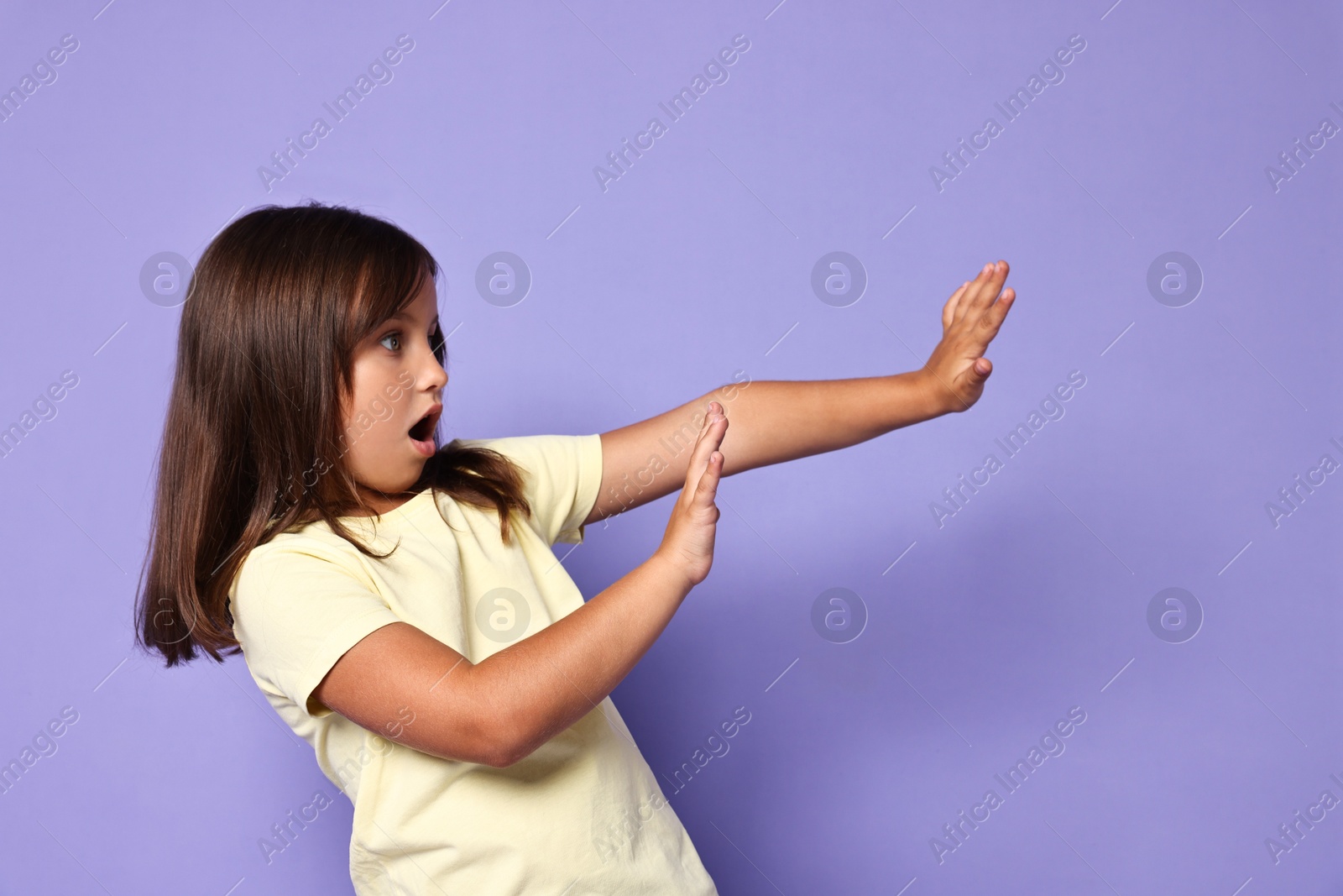 Photo of Portrait of scared little girl on violet background